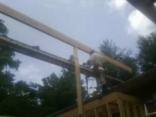 Carpenter setting a ridge beam over a new addition frame — Ice Dam Removal by Roofing Brothers in Government Camp