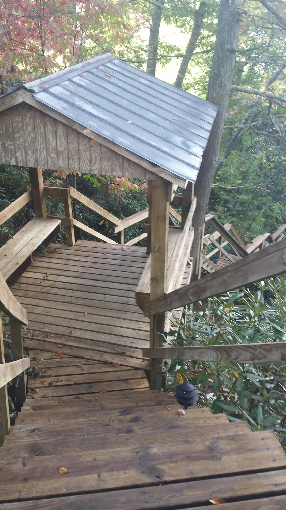 Metal roofed shelter over wooden steps on a wooded walkway — Skylight Repair & Installation work by our crew in Government Camp