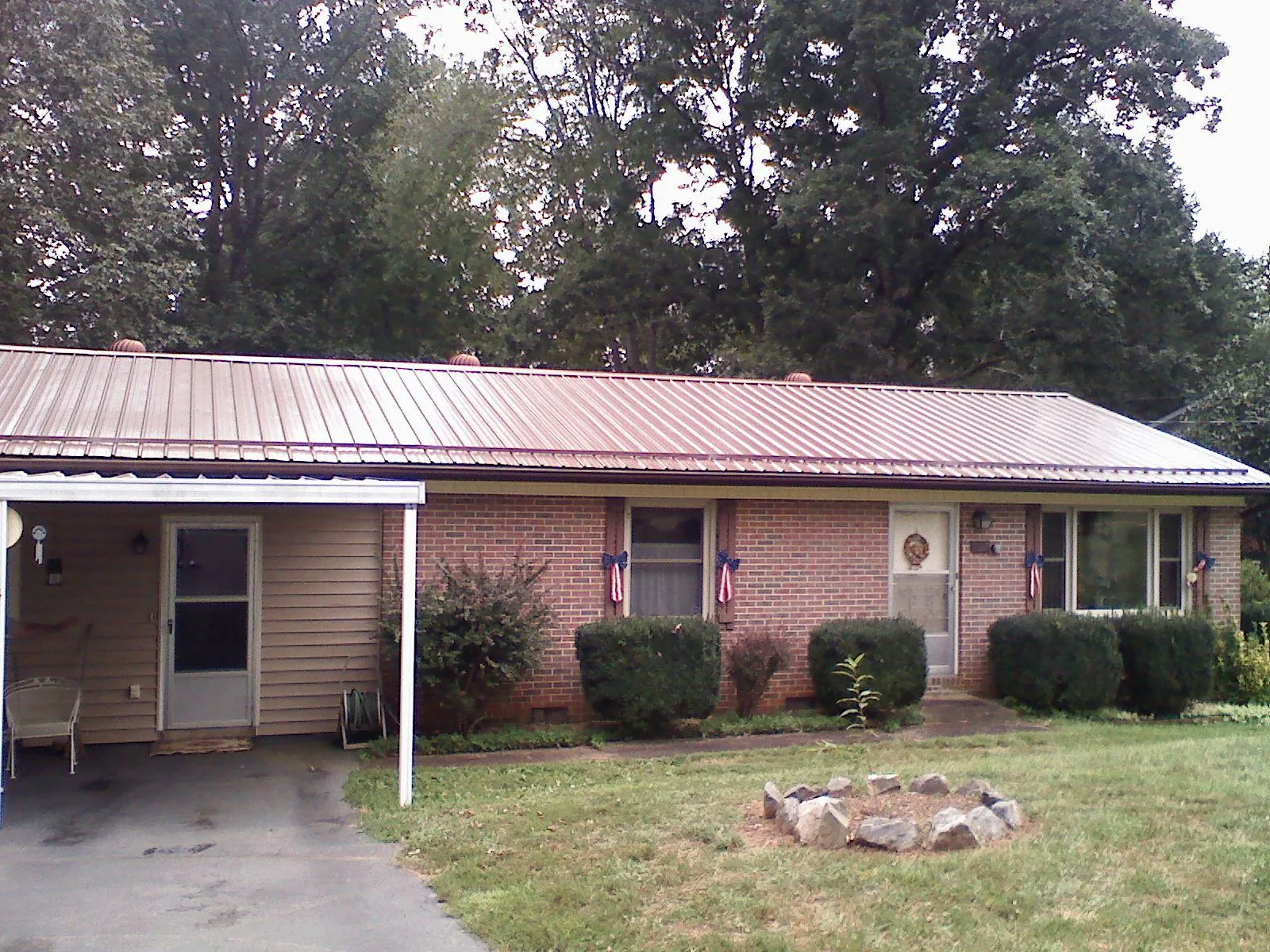 Bronze metal roof and carport on a brick ranch home — Roof Repair work by our crew in Government Camp